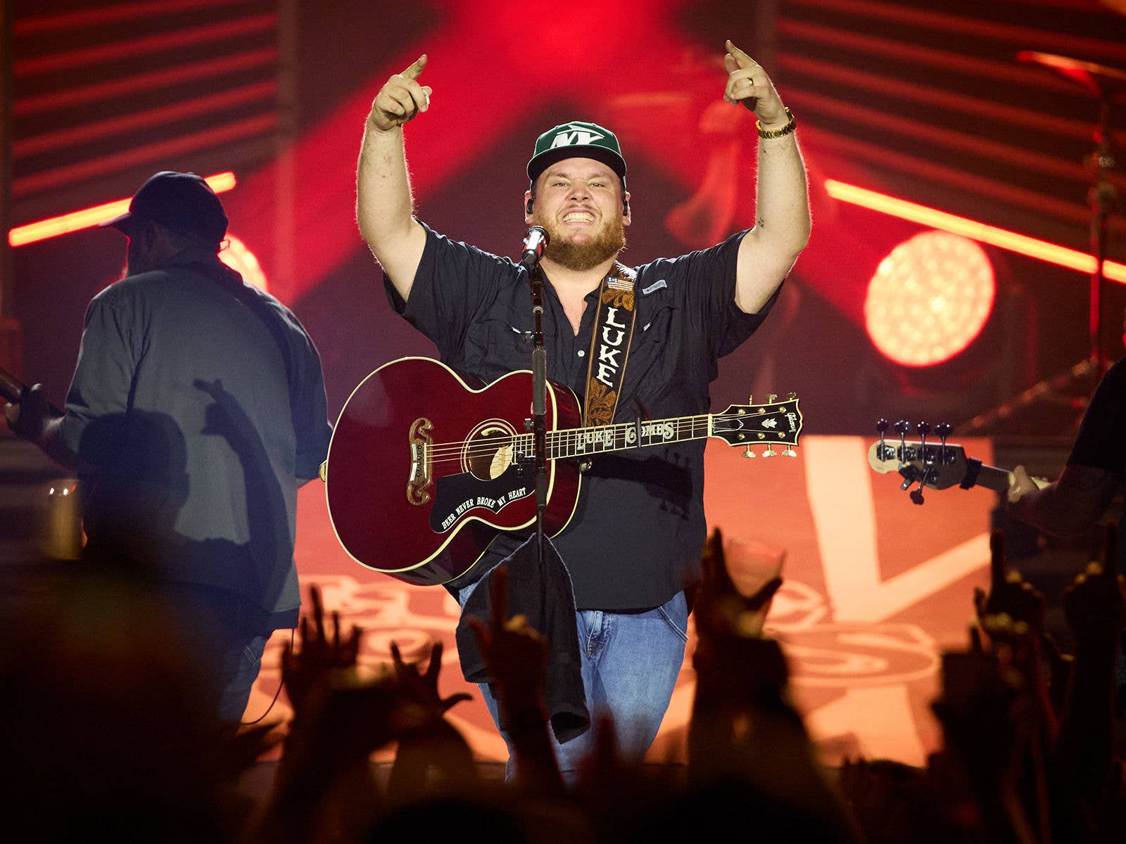 Luke Combs Luke Combs on stage with his guitar in front of a crowd